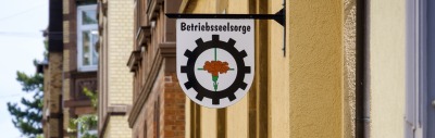 Aushängeschild mit der Aufschrift Betriebsseelsorg und dem Logo